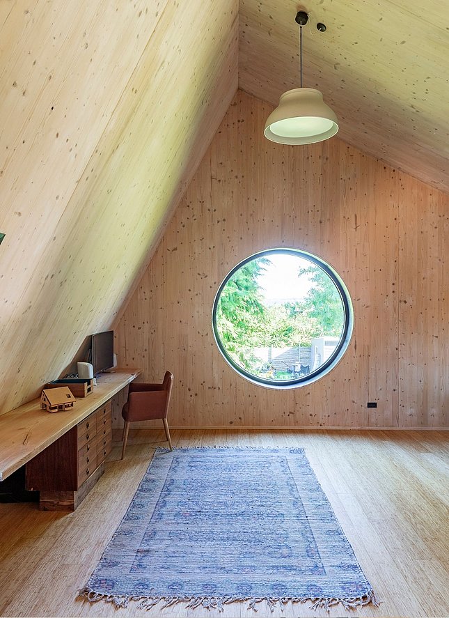 Arbejdsværelse i CLT-træ med rundt vindue