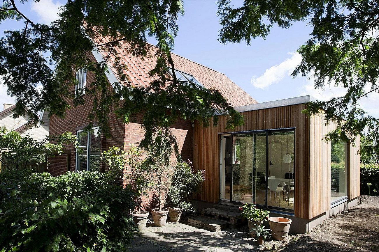 Tilbygning beklædt med lodrette lister af cedertræ til murermestervilla fra 50'erne