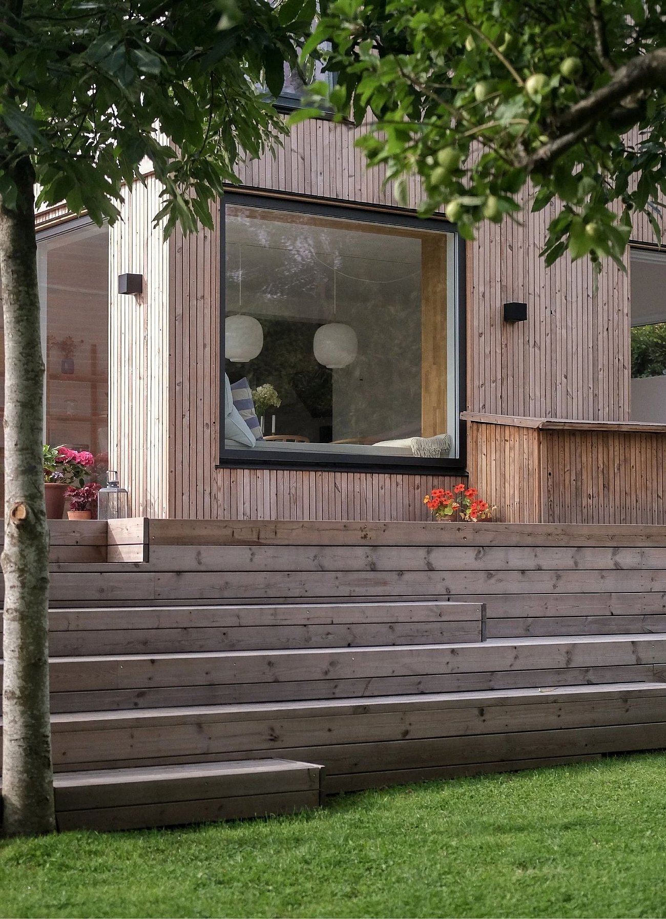 Træterrasse i flere niveauer med siddepladser og plantekasser