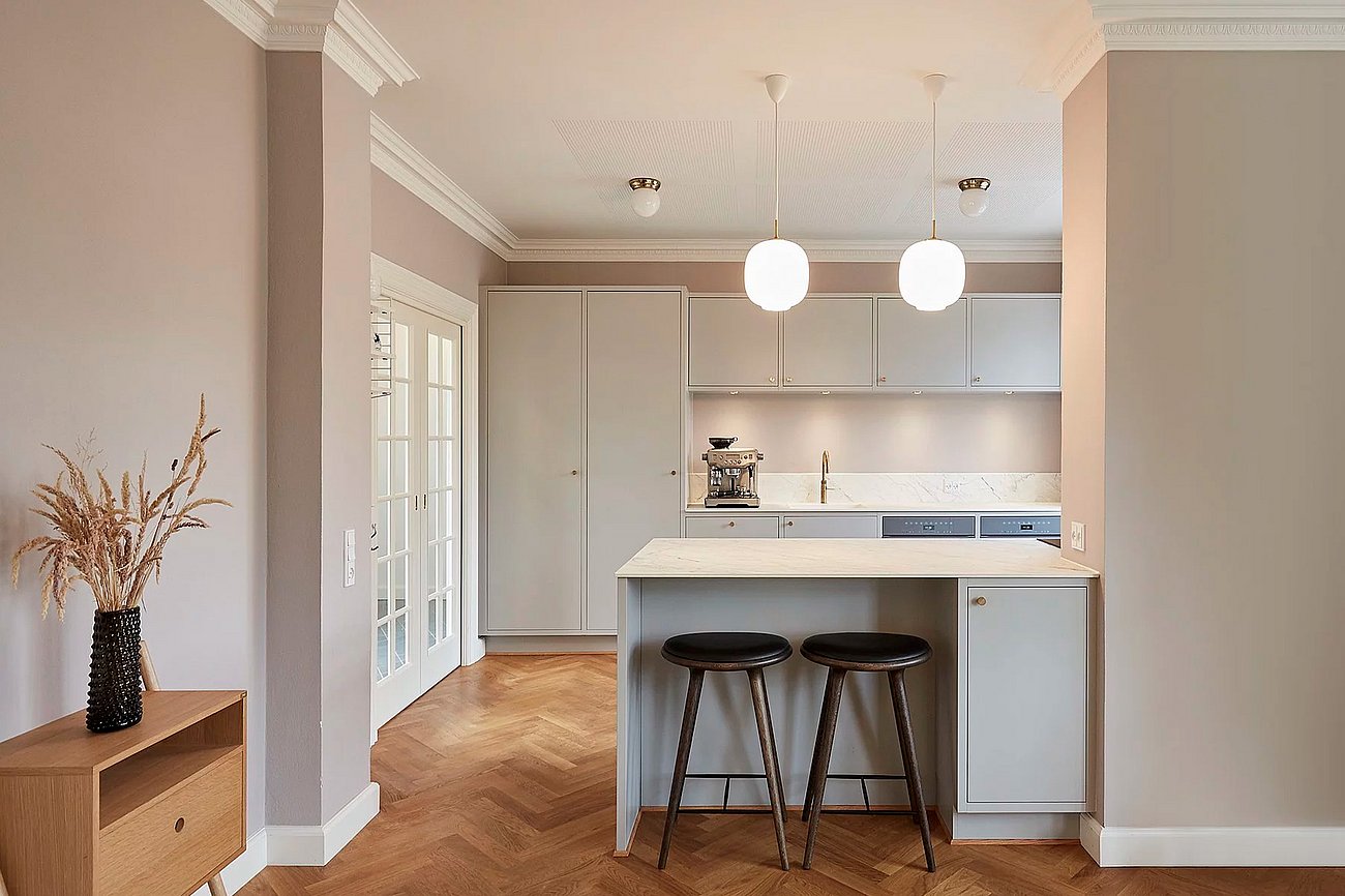 Lyst køkken med køkkenø og barstole