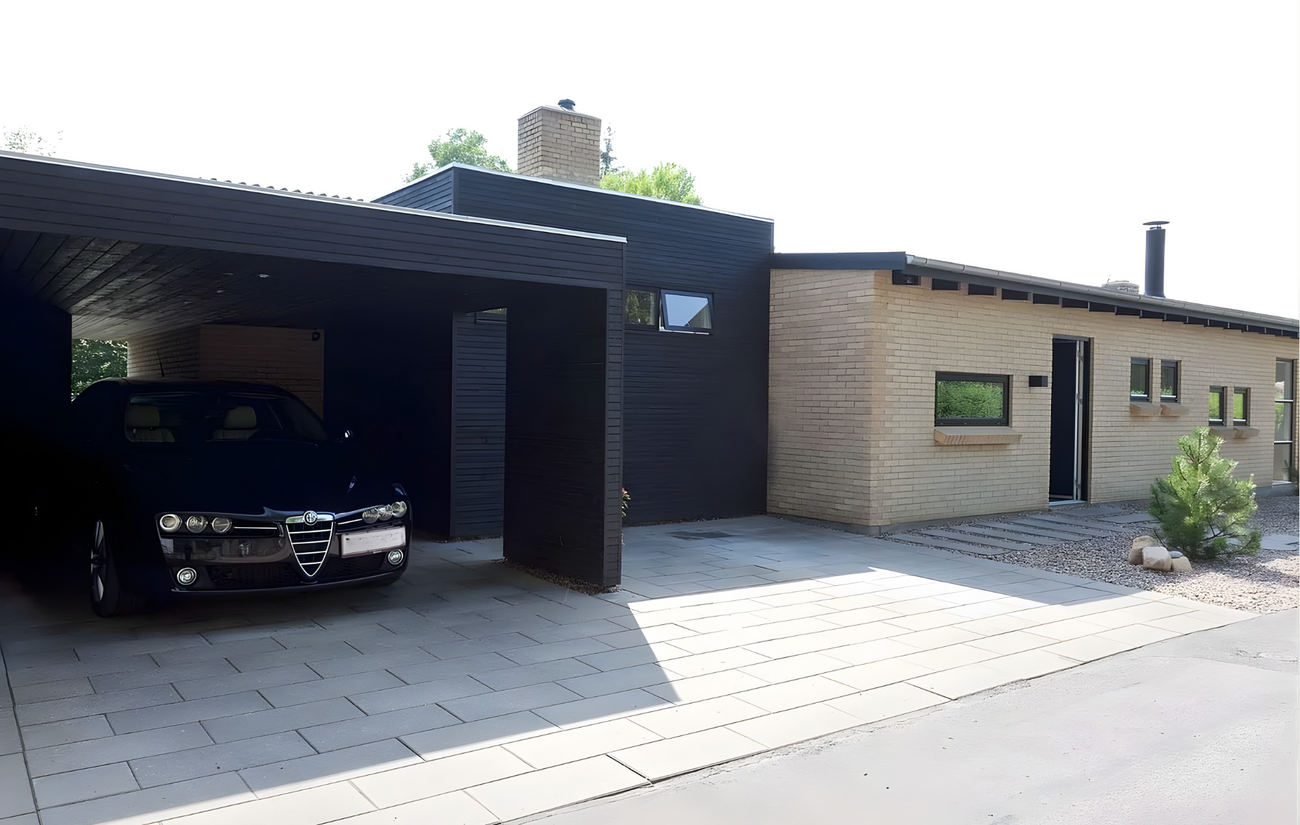 Tilbygning i sort træ skaber kontrast til gule mursten