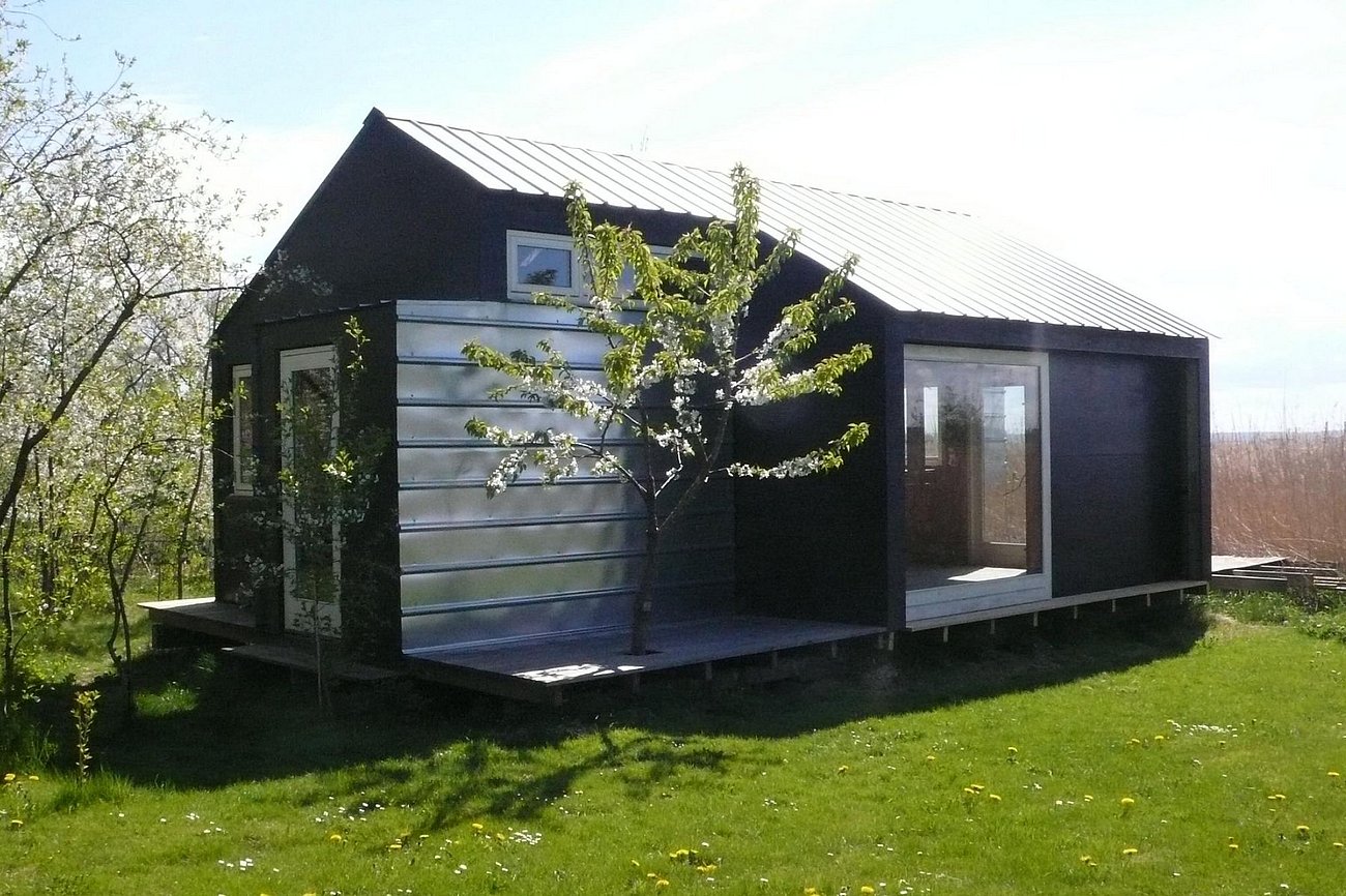 Småt sommerhus bygget udenom eksisterende træ