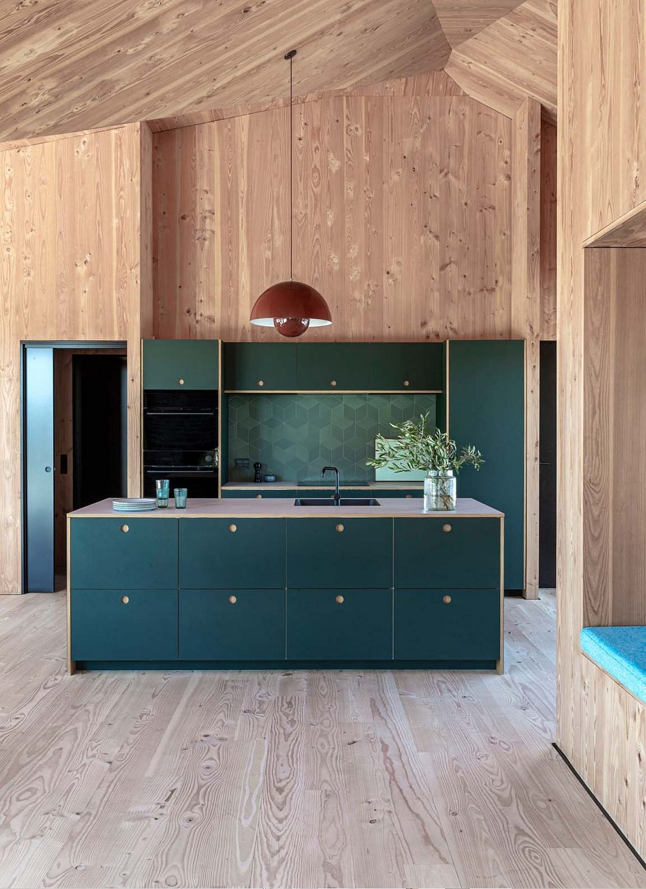 Sommerhus med mørkegrønt køkken fra REFORM med gråbeige bordplade og køkkenø