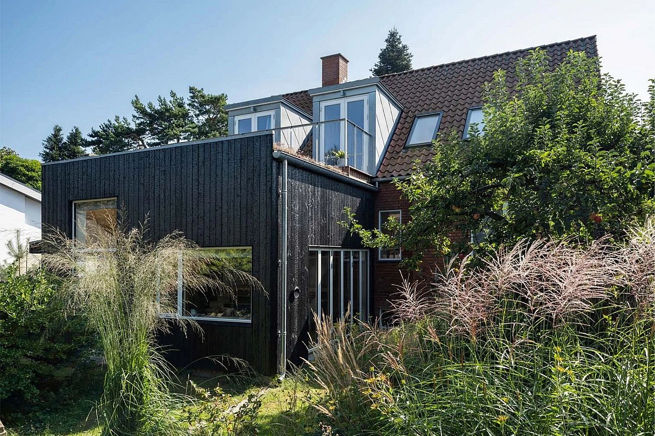 Murermestervilla fra 50'erne med tilbygning beklædt i sortmalet træ og sedumtag