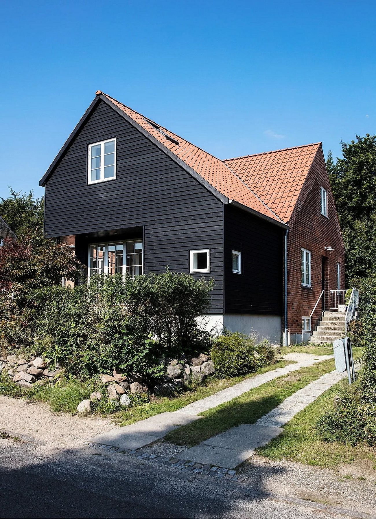 Tilbygning i sortmalet træ til statslånshus