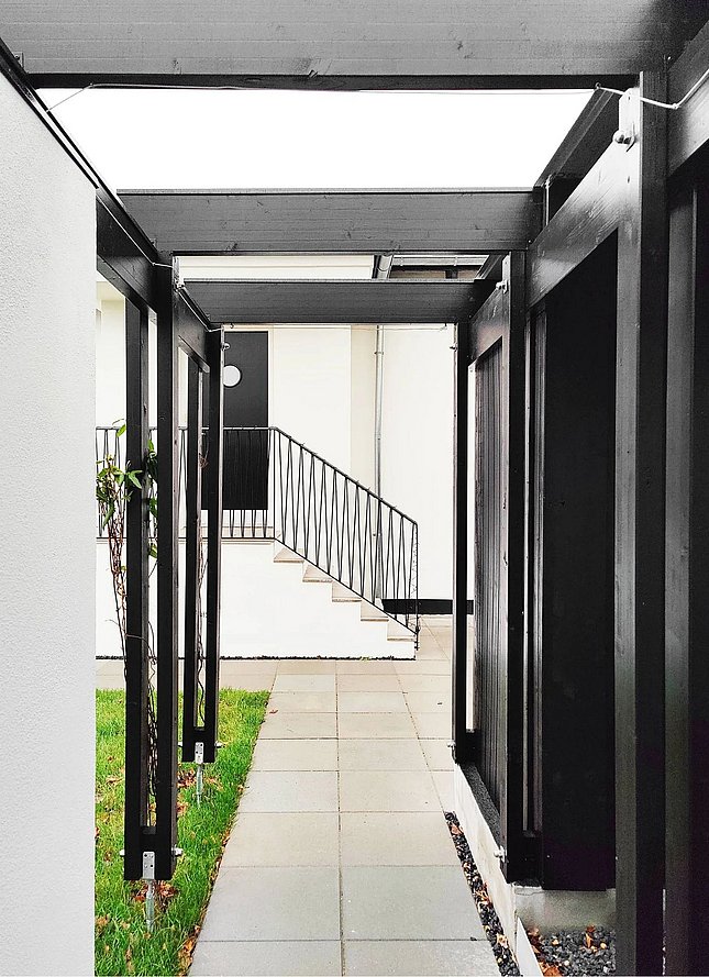 Carport i sortmalet træ med søjlegang
