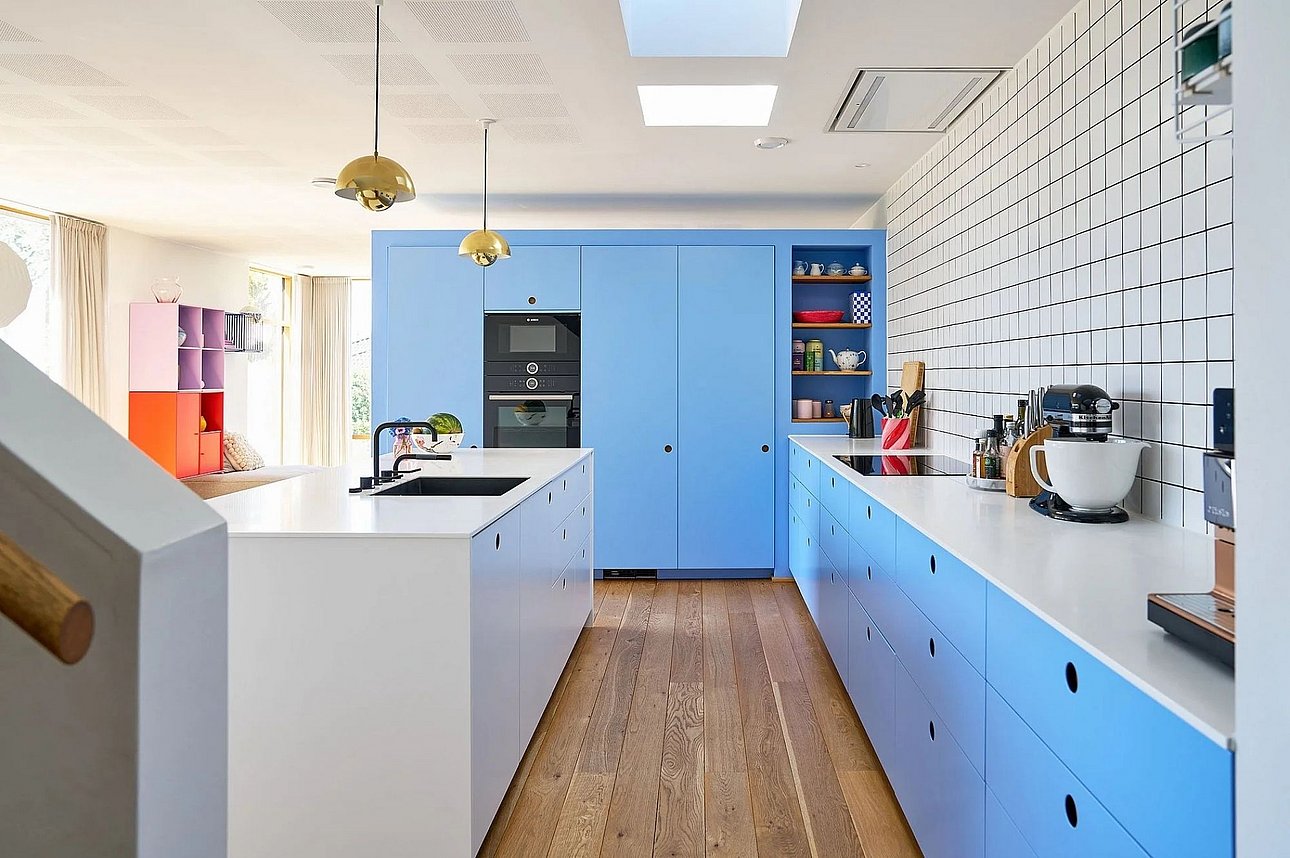 Blåt køkken med hvid Corian-bordplade og køkkenø