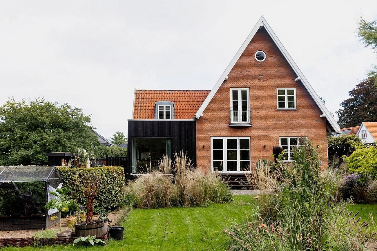 Tilbygning beklædt med sort træ til murermestervilla fra 50'erne