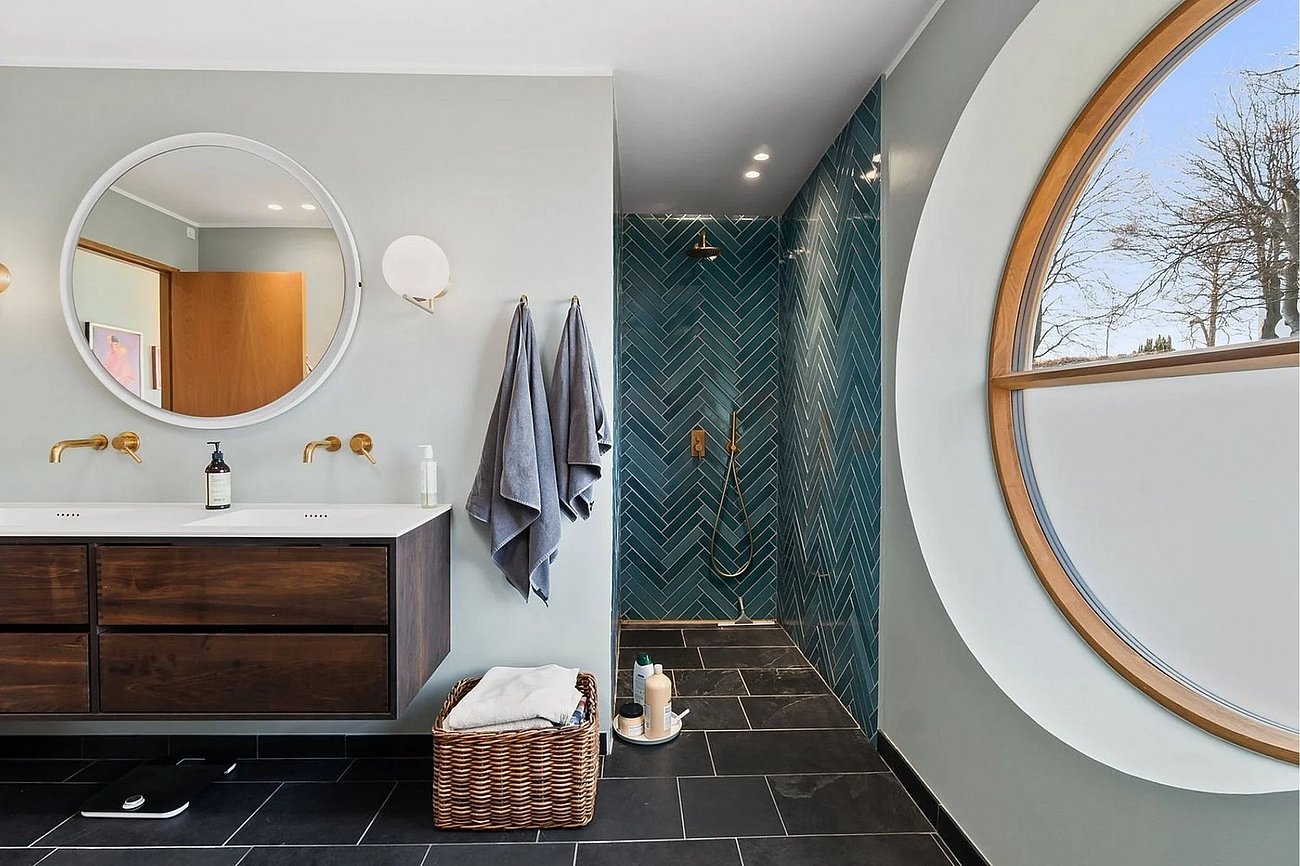 Stort toilet med rundt vindue i funkisvilla