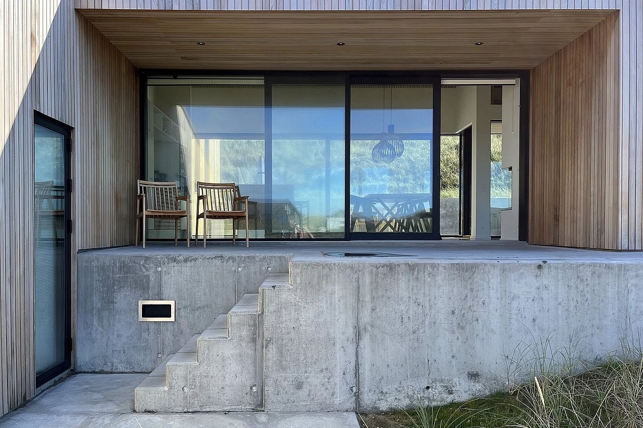 Træommerhus med betonfundament i flere niveauer i bakker