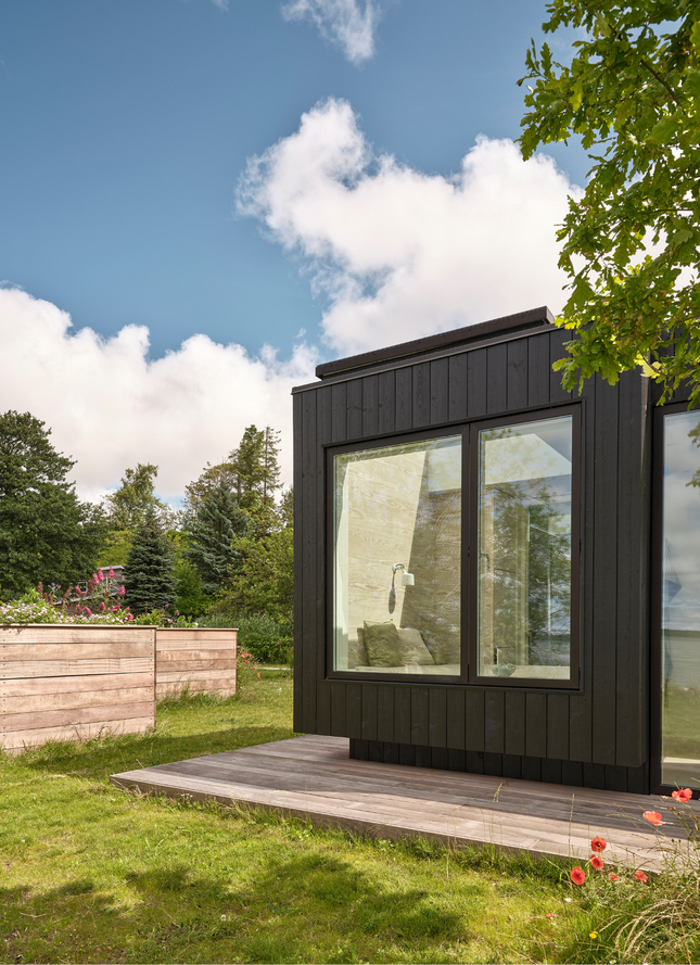 Sommerhus med der skyder ud af bygningen og svæver over jorden