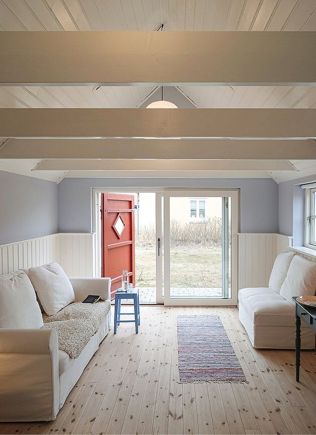 Stue med bjælker i klassisk Skagen sommerhus med 