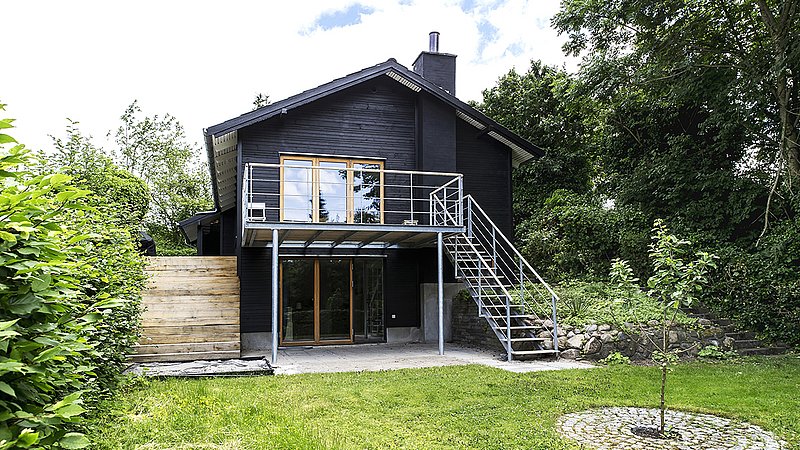 Huset fremstår åbent mod haven med en ny let altan og den sorte træfacade med terrassedøre i hårdttræ klæder de grønne omgivelser. m4 Arkitekter
Foto: Christina Kayser Onsgaard