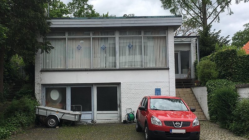 Facaden før ombygning og renovering med mursten og fuger plasticmalet hvidt
